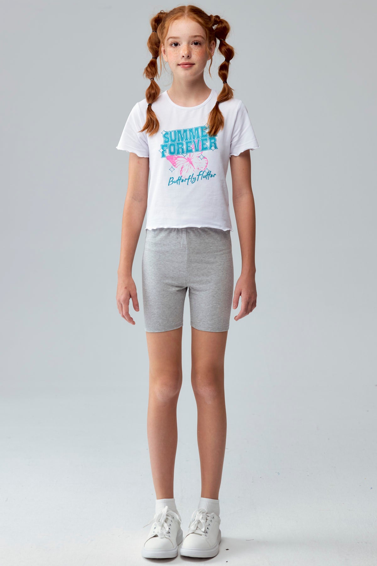 Calza niña biker rosado con estampado de íconos en fondo claro