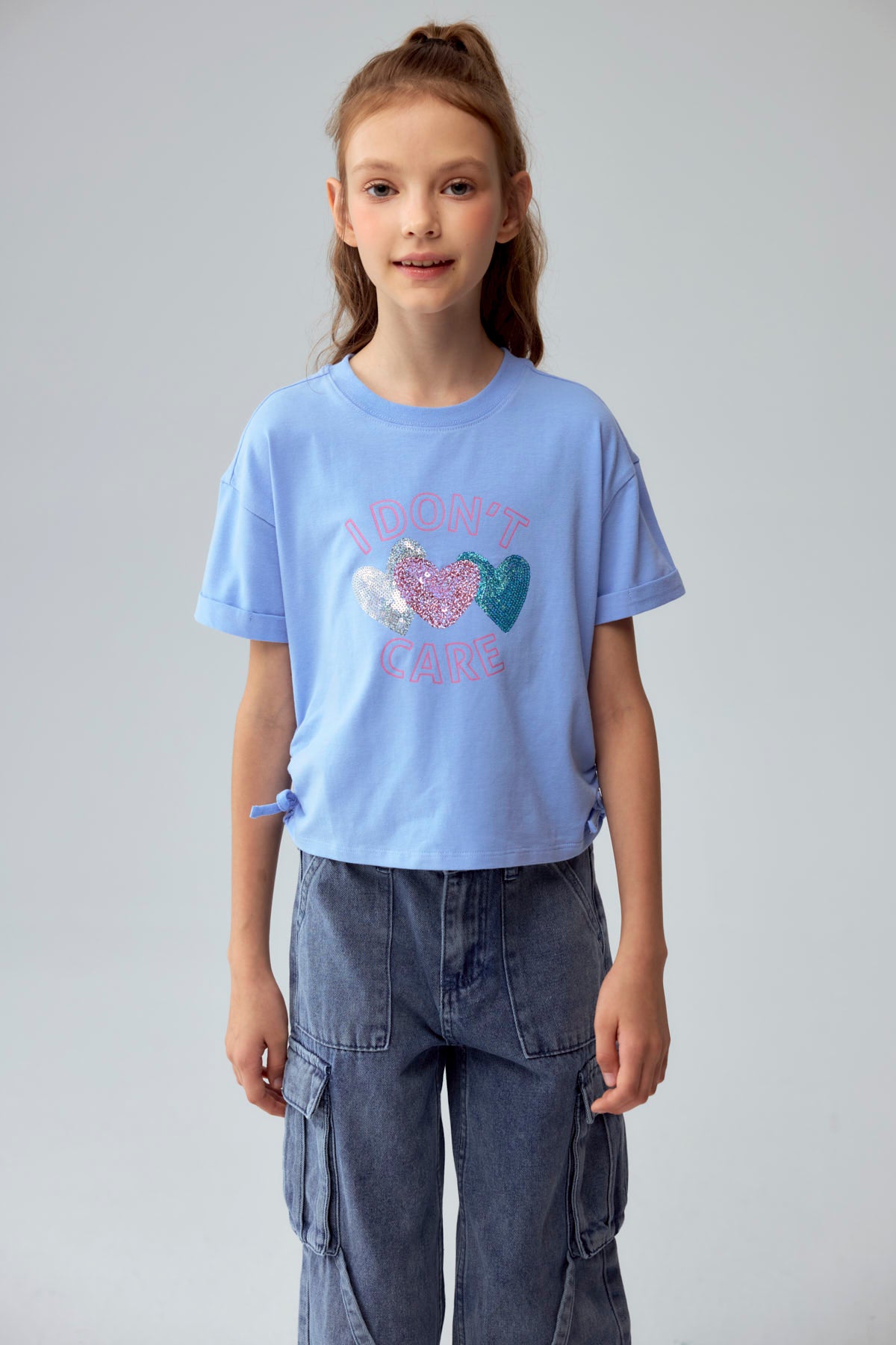 Polera azul para niña con estampado de corazones y texto I don't care
