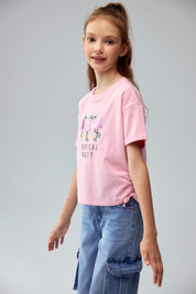 Polera rosada para niña con estampado de flamencos y texto Tropical Party
