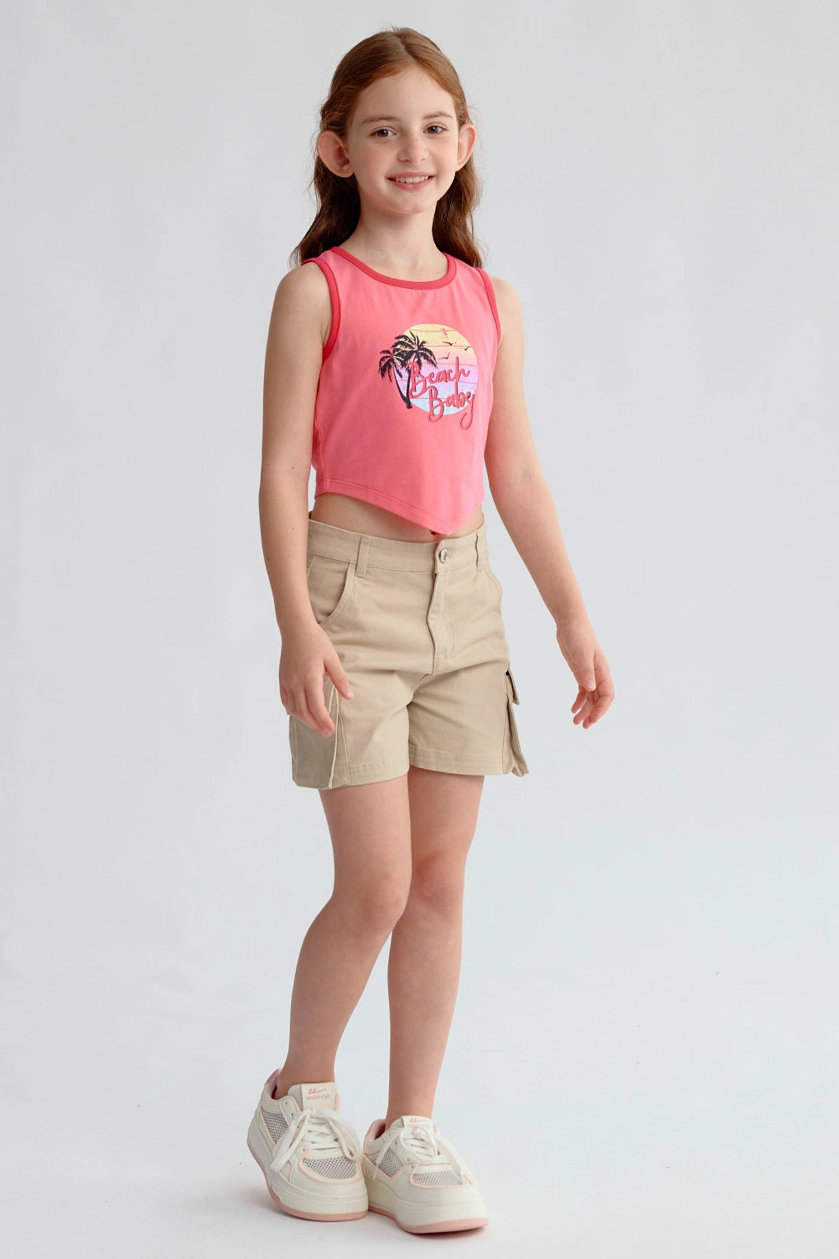 Polera niña fucsia con estampado de palmeras y texto Beach Babe