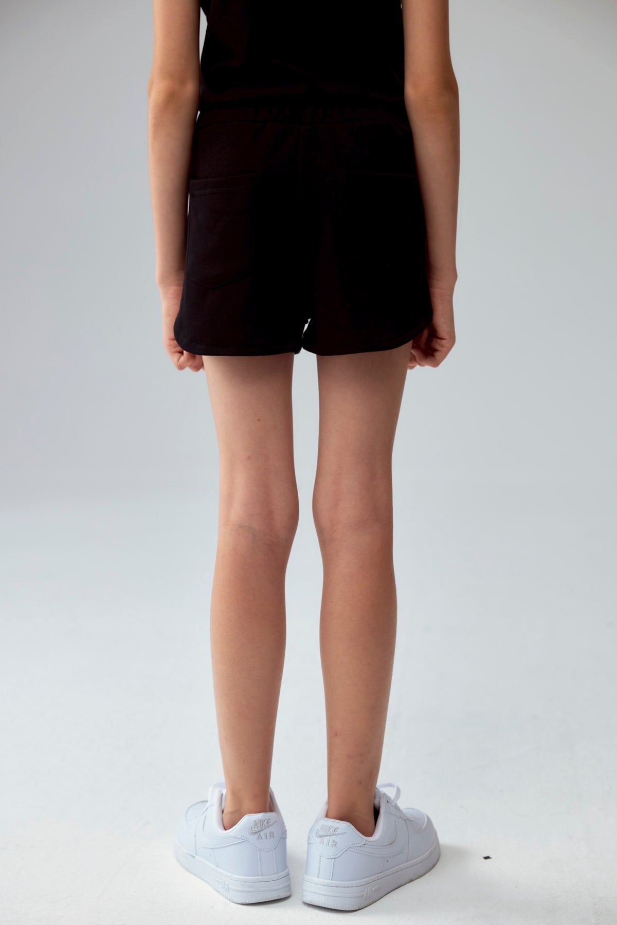 Short negro para niña con diseño liso y cordón ajustable visible