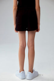 Short negro para niña con diseño liso y cordón ajustable visible