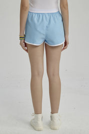 Short de baño celeste para niña con borde blanco y cintura ajustable lisa