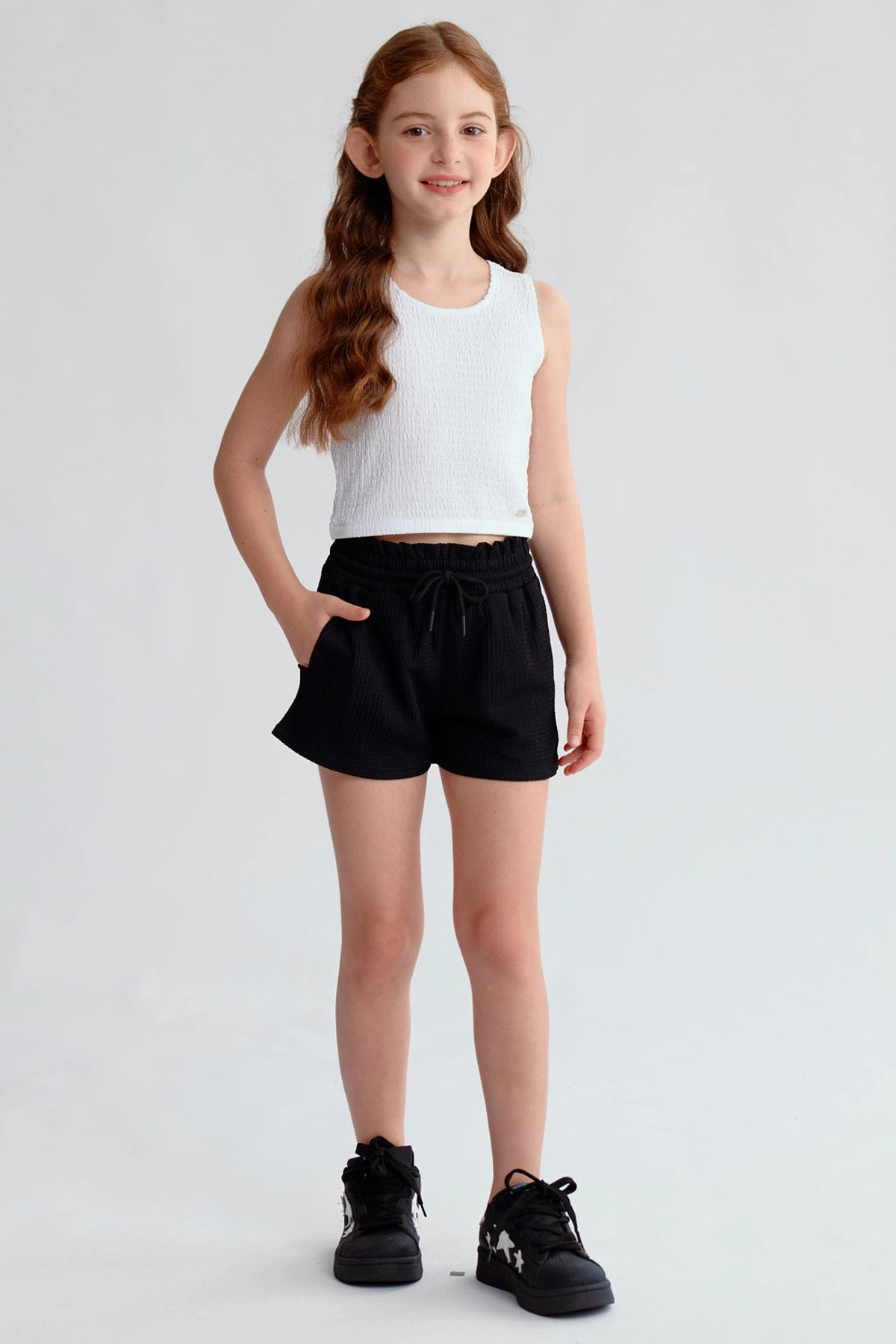 Short niña negro con textura y cintura elasticada visible