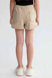 Short beige para niña con estampado de palmeras y texto en la pierna izquierda