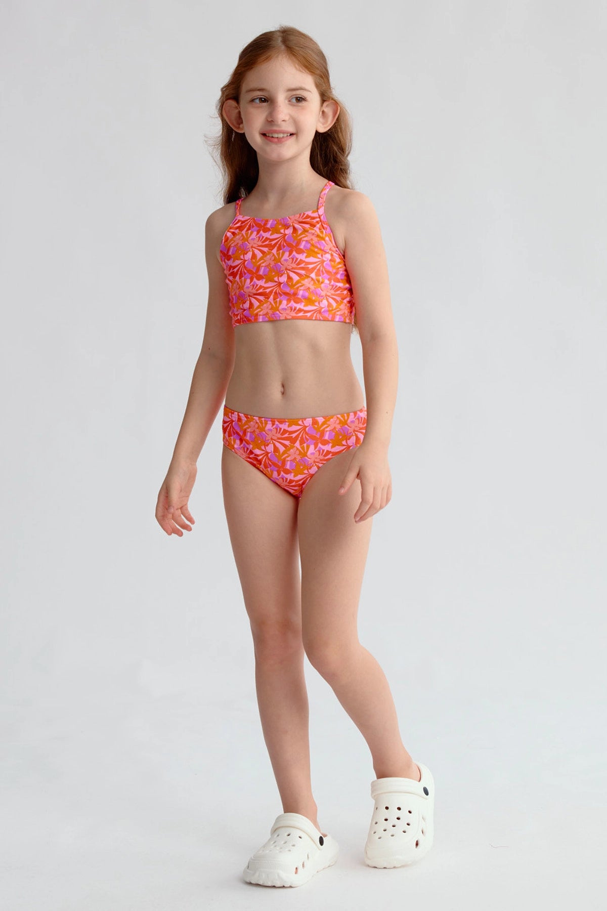 Traje de baño niña fucsia con estampado de hojas y espalda cruzada