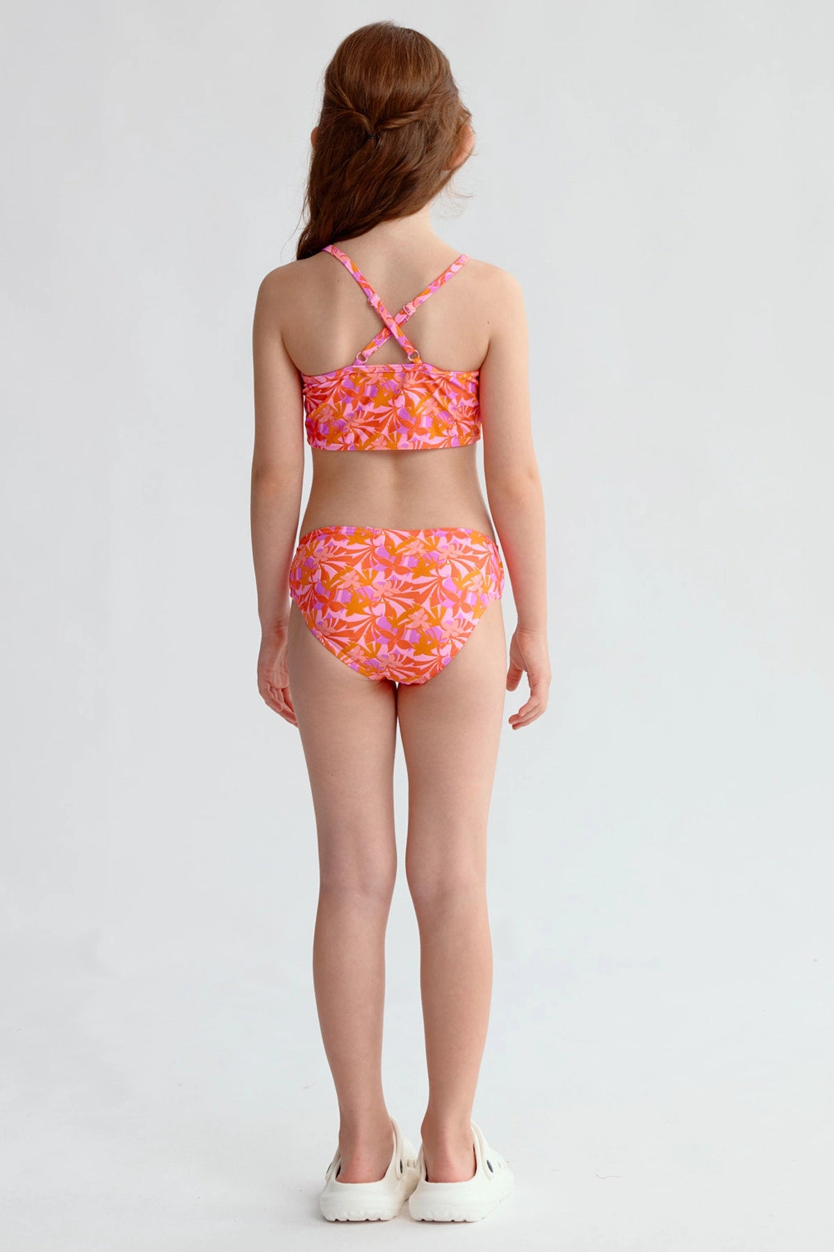 Traje de baño niña fucsia con estampado de hojas y espalda cruzada