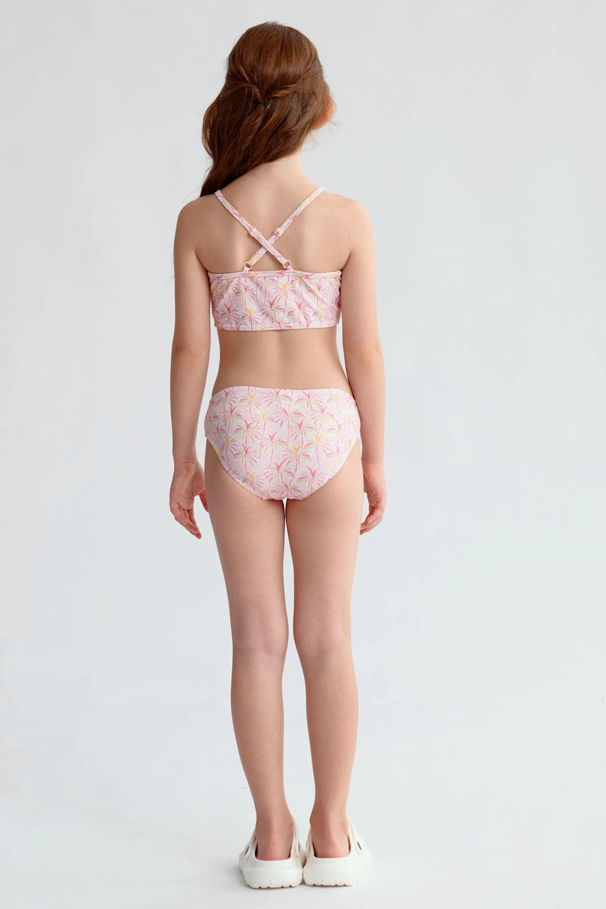 Traje de baño niña rosado con estampado floral y espalda cruzada