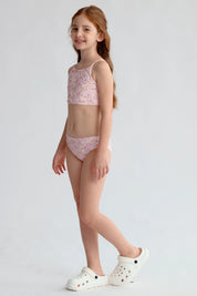 Traje de baño niña rosado con estampado floral y espalda cruzada