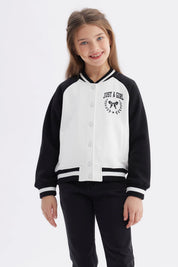 Chaqueta bomber negra para niña con mangas y cuello a rayas blancas estampa en el pecho de moño y texto Just a Girl