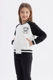 Chaqueta bomber negra para niña con mangas y cuello a rayas blancas estampa en el pecho de moño y texto Just a Girl