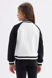 Chaqueta bomber negra para niña con mangas y cuello a rayas blancas estampa en el pecho de moño y texto Just a Girl