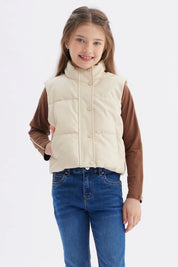 Chaleco sin mangas beige para niña con efecto acolchado y cuello alto prenda lisa y botones frontales