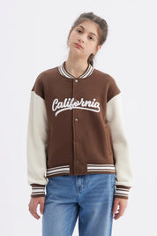Chaqueta bomber café para niña con mangas crema y texto California en el pecho estilo universitario casual