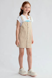 Jardinera tipo vestido beige para niña con botones frontales y bolsillos visibles