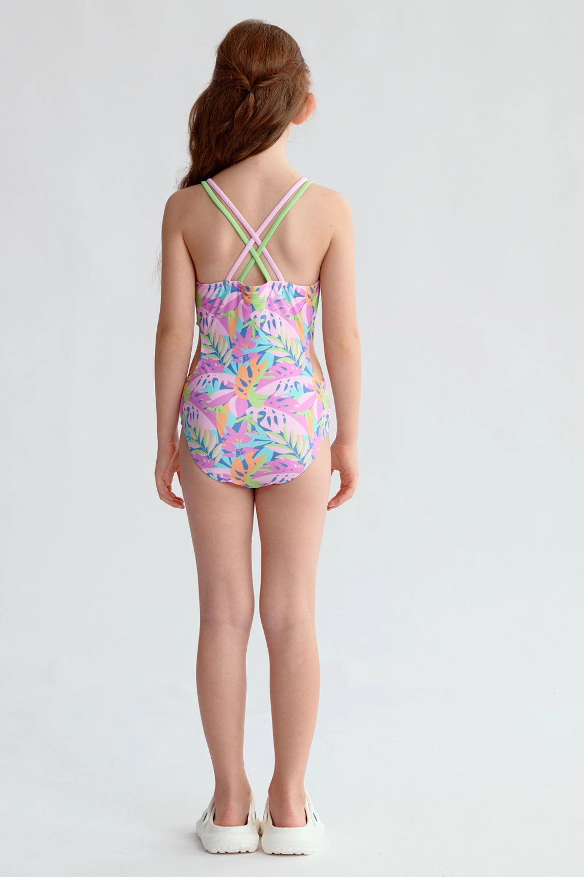 Traje de baño rosado para niña con estampado de hojas coloridas y espalda cruzada