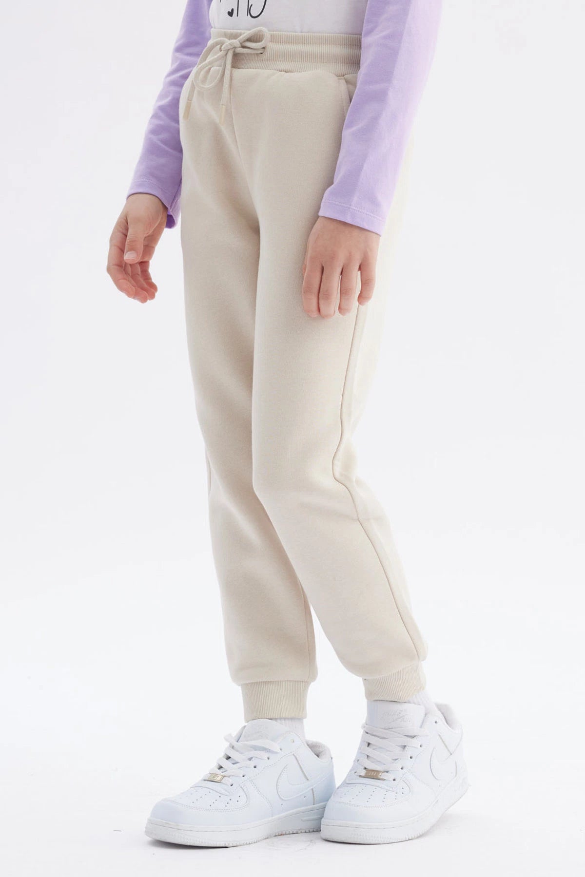 Pantalón buzo jogger beige niña con cintura elástica y bolsillos laterales lisa y cómoda ideal para el día a día