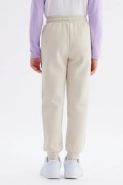Pantalón buzo jogger beige niña con cintura elástica y bolsillos laterales lisa y cómoda ideal para el día a día