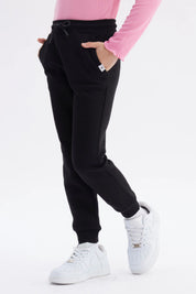 Pantalón jogger negro para niña con ajuste de cordón y puños elásticos diseño liso ideal para el día a día