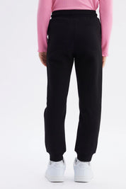 Pantalón jogger negro para niña con ajuste de cordón y puños elásticos diseño liso ideal para el día a día