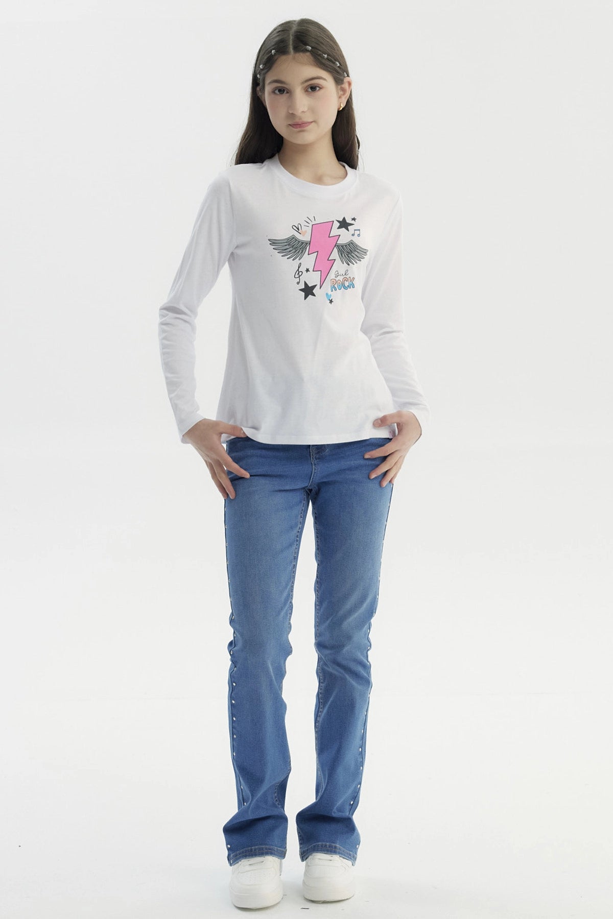 Polera blanca para niña con estampado de rayo rosa y alas negras en el centro rodeado de estrellas notas musicales y texto Girl Rock