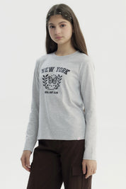 Polera niña gris melange con estampa central de mariposa y texto New York Local East Club en estilo universitario