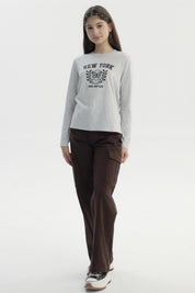 Polera niña gris melange con estampa central de mariposa y texto New York Local East Club en estilo universitario