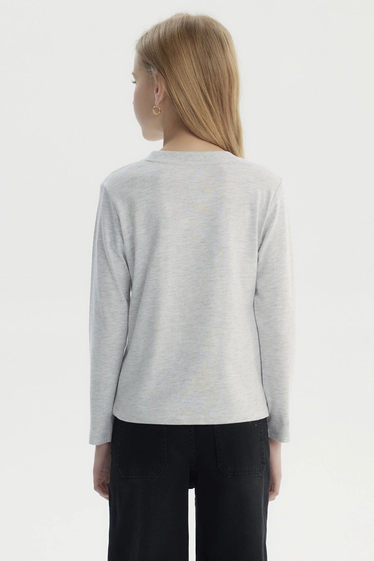 Polera gris melange de niña con estampa central de unicornio rosado rodeado de corazones y hojas doradas estilo dibujo