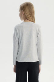 Polera gris melange de niña con estampa central de unicornio rosado rodeado de corazones y hojas doradas estilo dibujo