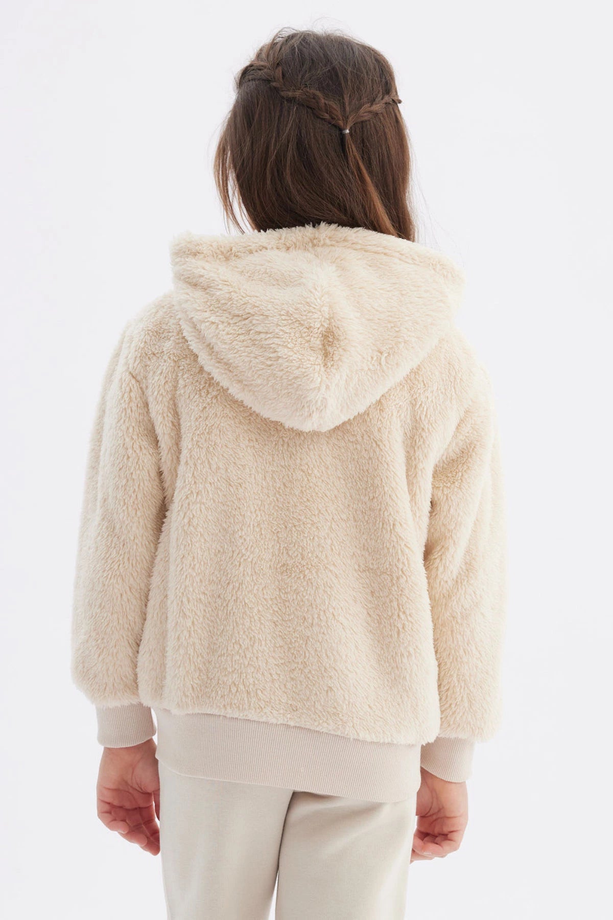 Polar niña beige con capucha y textura peluda cierre frontal y bolsillos delanteros diseño liso cómodo y abrigador