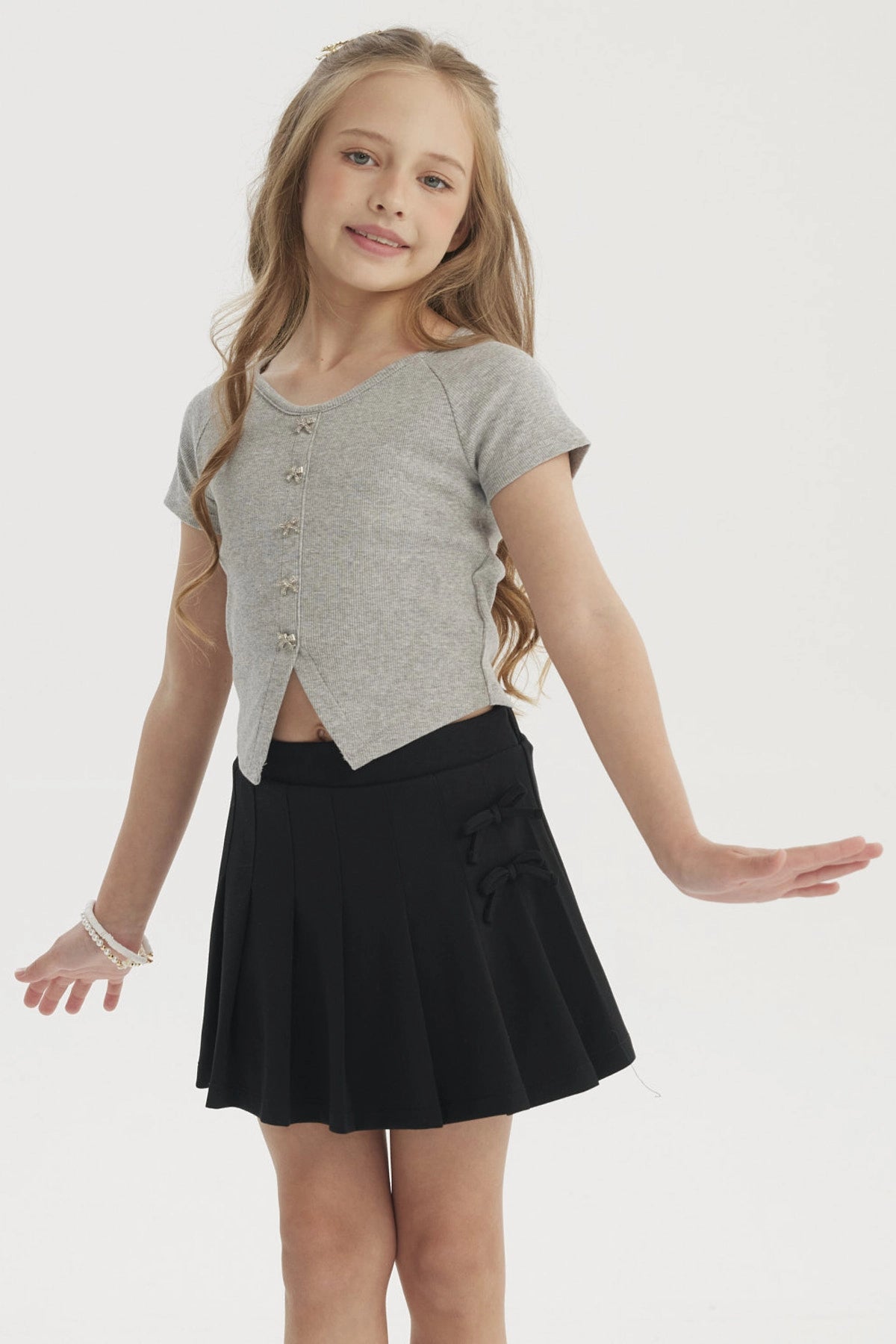Polera niña gris melange con botones decorativos al frente diseño de lazo lisa