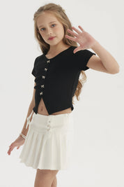 Polera negra para niña con botones de lazo pequeños en el frente estilo casual elegante sin estampa lisa