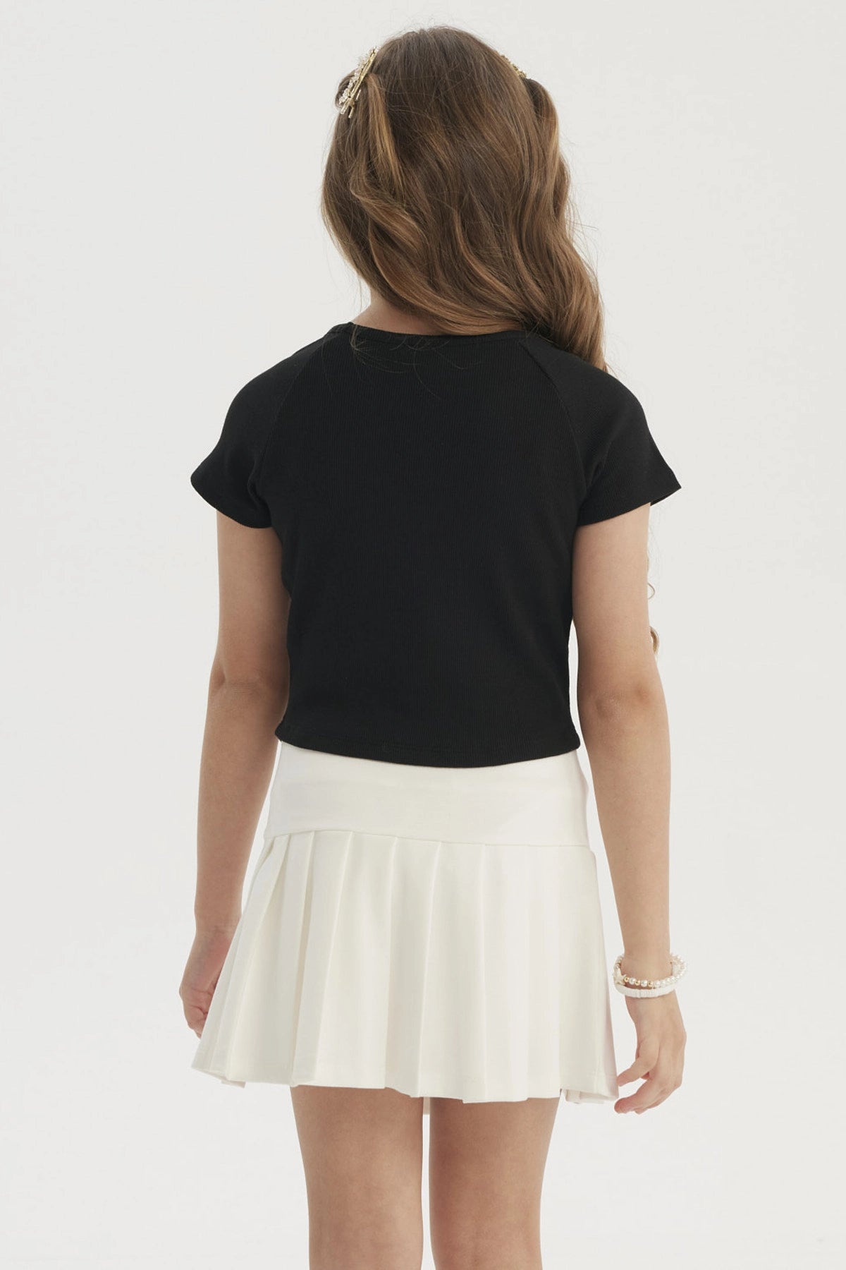 Polera negra para niña con botones de lazo pequeños en el frente estilo casual elegante sin estampa lisa
