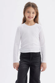 Polera blanca de manga larga para niña con diseño recogido en los laterales sin estampa lisa y minimalista