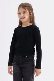 Polera negra para niña con diseño recogido en los laterales lisa y de manga larga ideal para un look casual