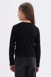 Polera negra para niña con diseño recogido en los laterales lisa y de manga larga ideal para un look casual