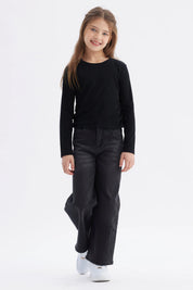Polera negra para niña con diseño recogido en los laterales lisa y de manga larga ideal para un look casual
