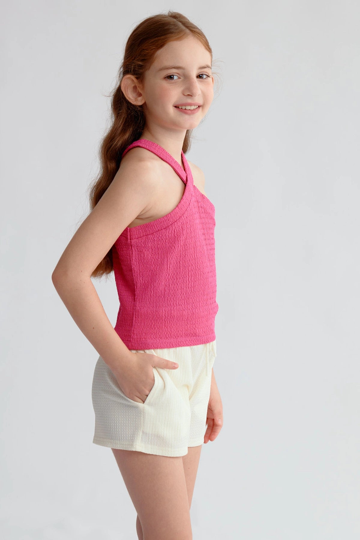 Peto niña color fucsia con textura y tirantes cruzados