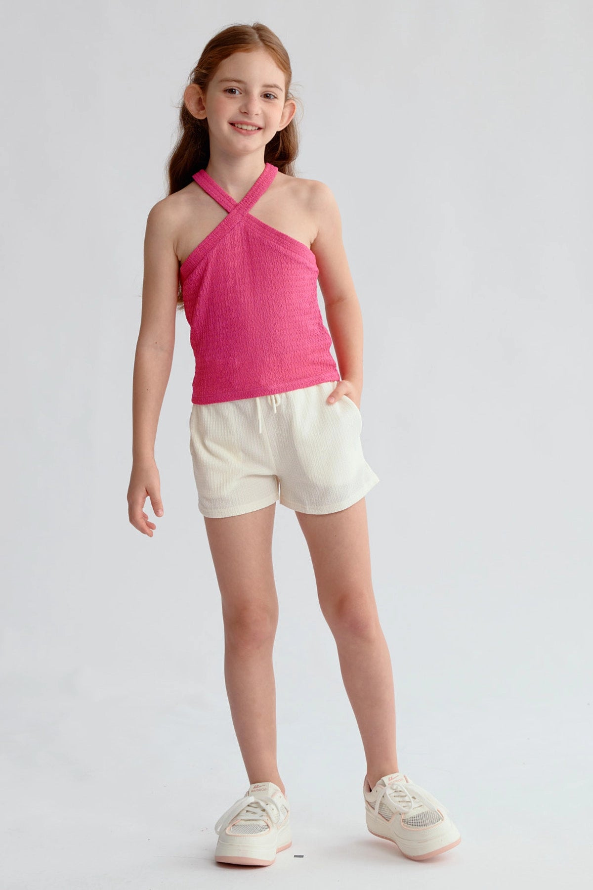 Peto niña color fucsia con textura y tirantes cruzados