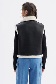 Chaqueta negra tipo biker para niña con detalles de piel blanca en el cuello y borde lisa y elegante