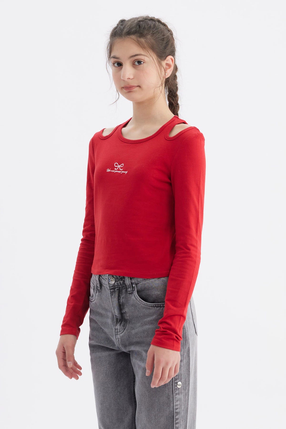 Polera roja de manga larga con aberturas en los hombros y estampa de lazo y texto We are forever young en el pecho