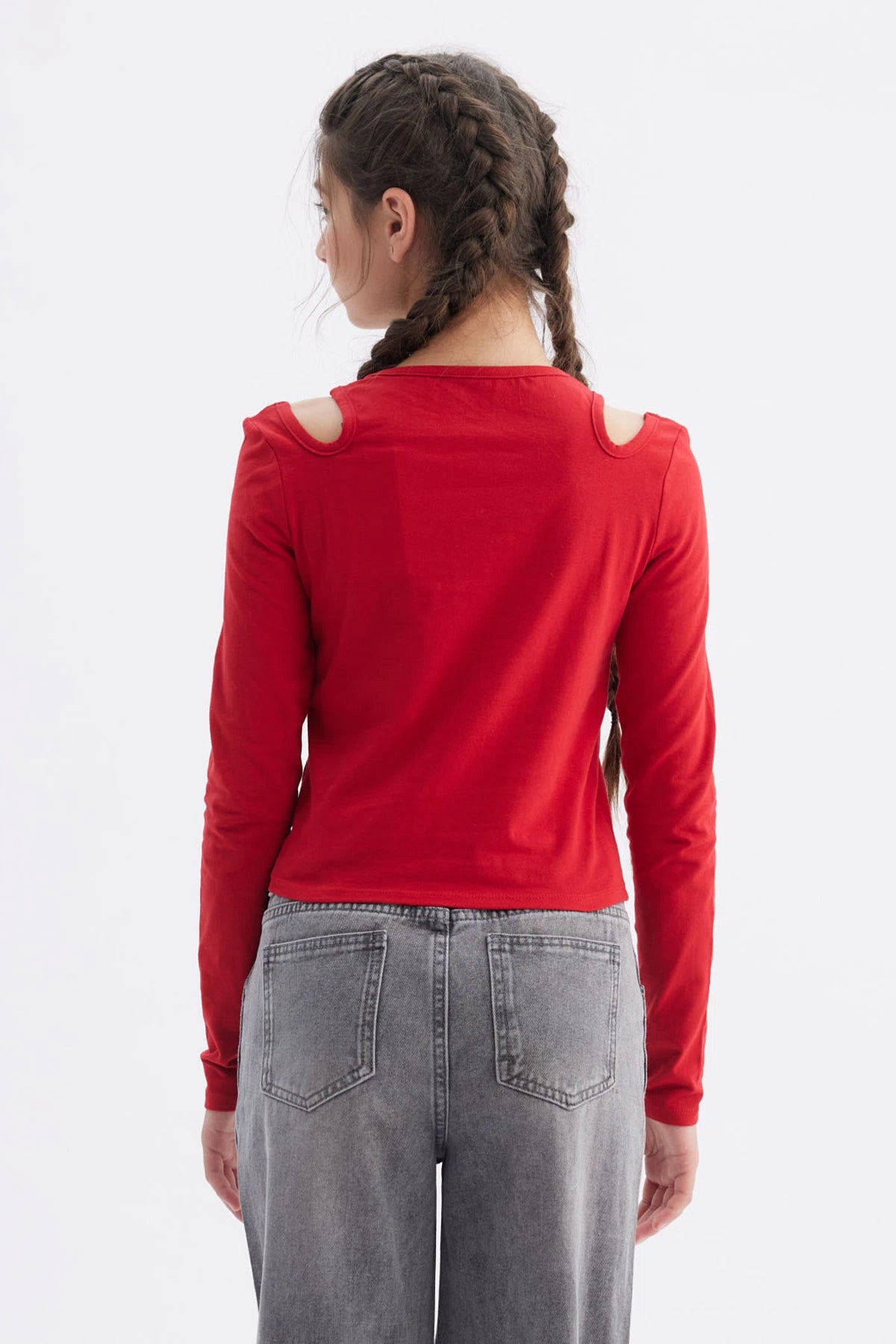 Polera roja de manga larga con aberturas en los hombros y estampa de lazo y texto We are forever young en el pecho