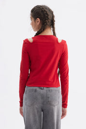 Polera roja de manga larga con aberturas en los hombros y estampa de lazo y texto We are forever young en el pecho