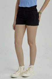 Short negro de niña estilo cargo con bolsillos laterales visibles y diseño liso perfecto para el verano