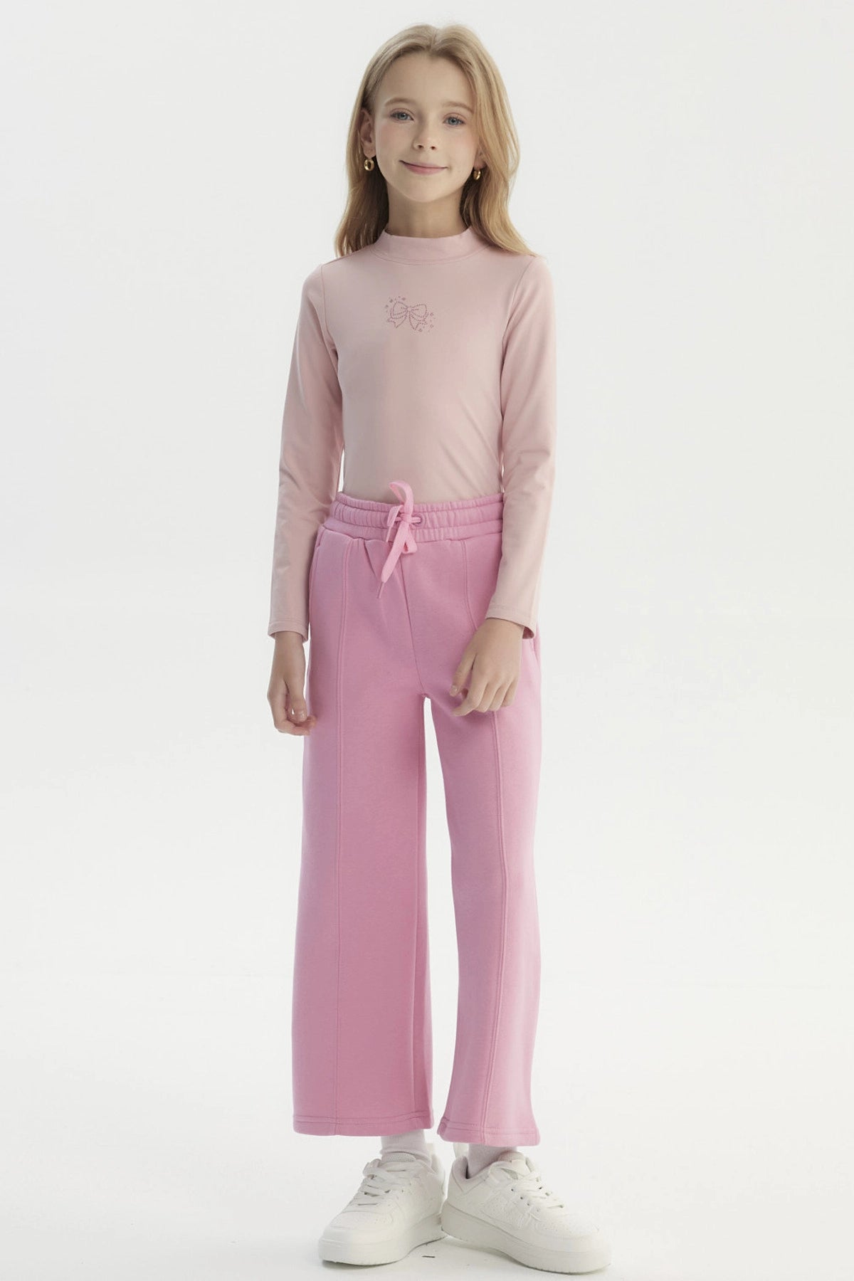 Pantalón buzo niña rosado de pierna ancha con cintura elástica y cordón ajustable diseño liso sin estampado