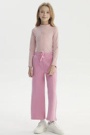 Pantalón buzo niña rosado de pierna ancha con cintura elástica y cordón ajustable diseño liso sin estampado