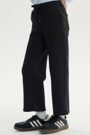 Pantalón buzo negro para niña de pierna ancha sin estampa con cintura elástica y ajuste con cordón