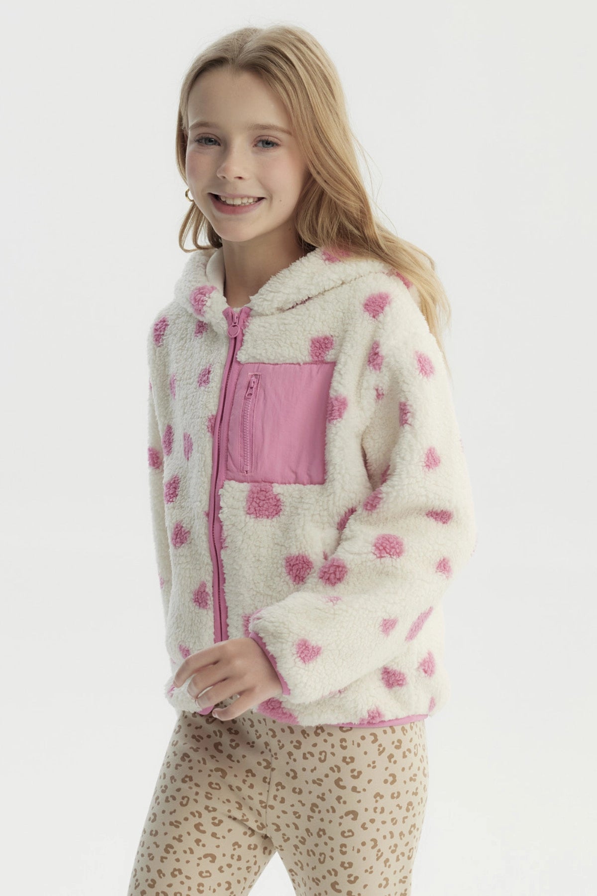 Polar para niña color crudo con corazones rosas estampados en toda la prenda bolsillo frontal y cierre completo