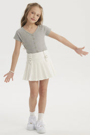 Falda niña tableada blanca con hebillas en la cintura prenda lisa ideal para un look fresco y cómodo