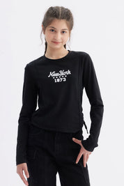 Polera niña slim negra con diseño frontal de letras blancas New York 1873 casual y moderna ideal para uso diario